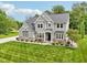 Well-maintained two-story home with stone accents, green lawn, and a well-manicured yard at 9155 Kerwood Dr, Indianapolis, IN 46240