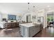 Open kitchen with gray island, stainless sink, and pendant lighting flows into the living area at 9155 Kerwood Dr, Indianapolis, IN 46240