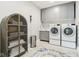 Functional laundry room with front-load washer/dryer and cabinet with granite countertop and sink at 9155 Kerwood Dr, Indianapolis, IN 46240