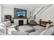 Living room featuring fireplace, a gray sectional sofa, dark wood floors, and staircase to second level at 9155 Kerwood Dr, Indianapolis, IN 46240