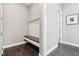 Cozy mudroom features a built-in bench with hooks and an adjacent hallway with a framed photo at 9155 Kerwood Dr, Indianapolis, IN 46240