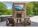 Covered patio with a stone fireplace, an outdoor television, and comfortable seating at 9155 Kerwood Dr, Indianapolis, IN 46240