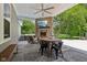 Outdoor patio with a stone fireplace, TV, hot tub, fan, and comfortable seating at 9155 Kerwood Dr, Indianapolis, IN 46240