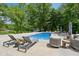 Backyard pool with lounge seating, mature trees, and natural landscaping, creating an outdoor retreat at 9155 Kerwood Dr, Indianapolis, IN 46240