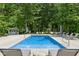 Refreshing backyard pool surrounded by lounge chairs, mature trees, and natural landscaping, creating a serene outdoor space at 9155 Kerwood Dr, Indianapolis, IN 46240