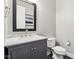Modern powder room featuring gray vanity with white countertop, a mirror and a toilet at 9155 Kerwood Dr, Indianapolis, IN 46240