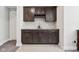 Wet bar with dark wood cabinets, granite countertops, wine rack, and tile flooring at 9155 Kerwood Dr, Indianapolis, IN 46240