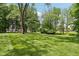 Expansive yard with lush grass and mature trees creating a serene and private setting at 9155 Kerwood Dr, Indianapolis, IN 46240