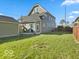 Large backyard with green grass and a wooden fence with other homes in the background at 921 S State Ave, Indianapolis, IN 46203