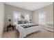 Bright bedroom featuring three windows, plush carpeting, and a bed with stylish black and white patterned throw at 921 S State Ave, Indianapolis, IN 46203