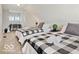 Well-lit bedroom featuring two twin beds, a desk, and comfortable bedding with stylish black and white patterned throws at 921 S State Ave, Indianapolis, IN 46203
