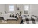 Cozy bedroom featuring two twin beds with comfortable bedding, patterned throws, and natural light from the windows at 921 S State Ave, Indianapolis, IN 46203