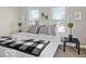 Inviting bedroom with two large windows, comfy pillows, decorative plants, and a stylish black and white patterned blanket at 921 S State Ave, Indianapolis, IN 46203