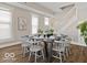 Bright dining room with hardwood floors, a large window, and a dark wood table set for eight guests at 921 S State Ave, Indianapolis, IN 46203