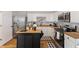 Well-lit kitchen featuring white cabinets, stainless steel appliances, wood countertops, and a black kitchen island at 921 S State Ave, Indianapolis, IN 46203