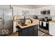 Modern kitchen featuring stainless steel appliances, white cabinets, wood countertops, and a decorative chicken at 921 S State Ave, Indianapolis, IN 46203