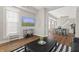 Cozy living room with a television and a view into the dining area and staircase at 921 S State Ave, Indianapolis, IN 46203