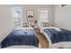 Stylishly decorated bedroom features two twin beds with soft carpet and lots of natural light at 923 S State Ave, Indianapolis, IN 46203