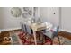 Inviting dining area featuring a rustic table with seating for six, complemented by decorative wall art and hardwood floors at 923 S State Ave, Indianapolis, IN 46203