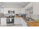 Modern kitchen featuring white cabinets, wood countertops, and stainless steel appliances offers a stylish and functional cooking area at 923 S State Ave, Indianapolis, IN 46203