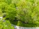 Aerial view of the wooded lot with the home nestled among the trees at 9387 Sullivan Pl, Zionsville, IN 46077