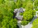 An aerial view showing a luxury home surrounded by mature trees, and a three car garage at 9387 Sullivan Pl, Zionsville, IN 46077