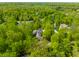 An aerial view of a beautiful home surrounded by mature trees and greenery with a long driveway at 9387 Sullivan Pl, Zionsville, IN 46077