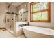 Bright bathroom featuring glass shower, soaker tub, large window and neutral color palette at 9387 Sullivan Pl, Zionsville, IN 46077