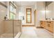 Bright bathroom with glass shower, wood vanity and large window at 9387 Sullivan Pl, Zionsville, IN 46077