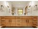 Modern bathroom vanity with double sinks, wood cabinets, black hardware and decorative lighting at 9387 Sullivan Pl, Zionsville, IN 46077