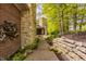 Exterior view of a walkway leading to a home with brick and stone elements surrounded by lush green trees at 9387 Sullivan Pl, Zionsville, IN 46077