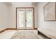 Bright foyer featuring tiled floors, white french doors, and modern artwork creating an elegant entrance at 9387 Sullivan Pl, Zionsville, IN 46077