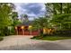 View of the home's 3-car garage and basketball hoop surrounded by lush landscaping at 9387 Sullivan Pl, Zionsville, IN 46077