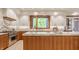 A modern kitchen featuring stainless steel appliances and a center island, complemented by natural light from a large window at 9387 Sullivan Pl, Zionsville, IN 46077