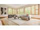 Living room features hardwood floors, many large windows with an oversized sofa, and modern furniture at 9387 Sullivan Pl, Zionsville, IN 46077
