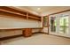 Home office features a custom built-in desk, shelving, and a double door to a balcony at 9387 Sullivan Pl, Zionsville, IN 46077