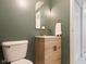 Updated half-bath featuring modern fixtures, a stylish vanity, and trendy green walls at 9493 Timber View Dr, Indianapolis, IN 46250