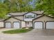 Attractive townhome with two-car garage, green trim, neutral siding, and beautifully landscaped grounds at 9493 Timber View Dr, Indianapolis, IN 46250