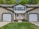 Inviting townhome featuring a two-car garage, neutral siding, green trim, and a well-maintained lawn at 9493 Timber View Dr, Indianapolis, IN 46250