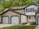 Charming townhome features a two-car garage, neutral siding, green trim, and a well-manicured lawn at 9493 Timber View Dr, Indianapolis, IN 46250