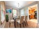 Cozy dining room with glass-top table, seating for six, and view to the kitchen and door to yard at 980 Red Maple Ct, Greenwood, IN 46143
