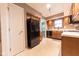 Efficient kitchen layout with wood cabinetry, full-size refrigerator, and access to additional spaces at 980 Red Maple Ct, Greenwood, IN 46143