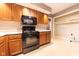 Well-lit kitchen boasts wood cabinets, black appliances, and ample counter space for meal preparation at 980 Red Maple Ct, Greenwood, IN 46143