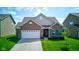 Charming brick home with a well-manicured lawn and two-car garage on a sunny day at 9823 Pica Dr, Fishers, IN 46040
