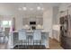 Modern kitchen with stainless steel appliances, an island, and elegant pendant lighting at 9823 Pica Dr, Fishers, IN 46040