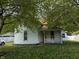 Charming house with light blue siding, front porch, and partially shaded by mature trees at 9976 W Center St, Anderson, IN 46011