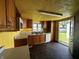 Kitchen with wood cabinets, white appliances, and an open door to the backyard at 9976 W Center St, Anderson, IN 46011