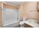 Bathroom with standard toilet, sink, and tub/shower combo with white tub surround at 101 N Westbury Rd, Pendleton, IN 46064