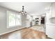 Bright kitchen features stainless steel appliances, gray backsplash, white cabinets and a wood and tile floor at 101 N Westbury Rd, Pendleton, IN 46064