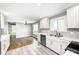 Bright kitchen with stainless steel appliances, tile backsplash, white cabinets, and a view into the dining room at 101 N Westbury Rd, Pendleton, IN 46064